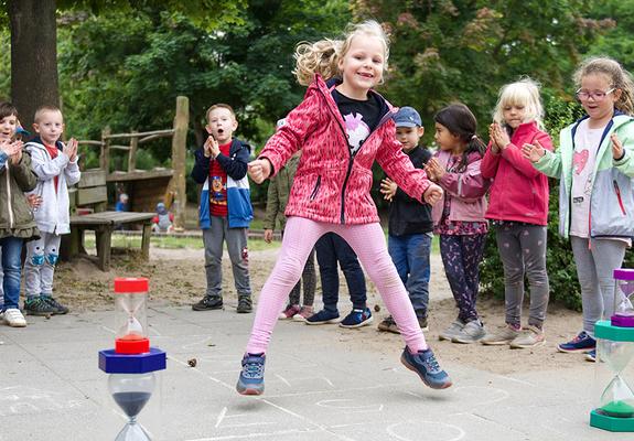 Im Jahresprojekt „Rad der Zeit“ probieren die Kids der Kita Sonnenschein unter anderem altbewährte Spiele aus. Elena und ihre Freunde hüpfen Hinkelkästchen