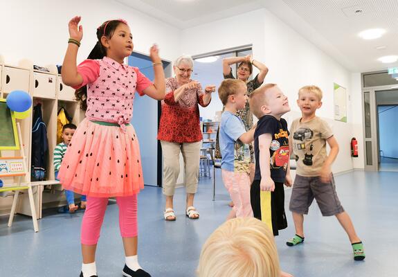 Beim Betreten der Kita ertönt erst Musik, dann herrscht Stille mit etwas verhaltenem Gekicher. Stopptanz ist angesagt – für die Kinder und zwei Seniorinnen