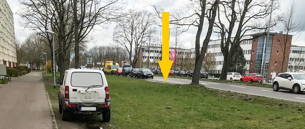 Obwohl ausreichend freie Parkplätze in der Grevesmühlener Straße vorhanden sind (gelber Pfeil), parken häufig Fahrzeuge auf der öffentlichen Grünfläche, Foto: SDS