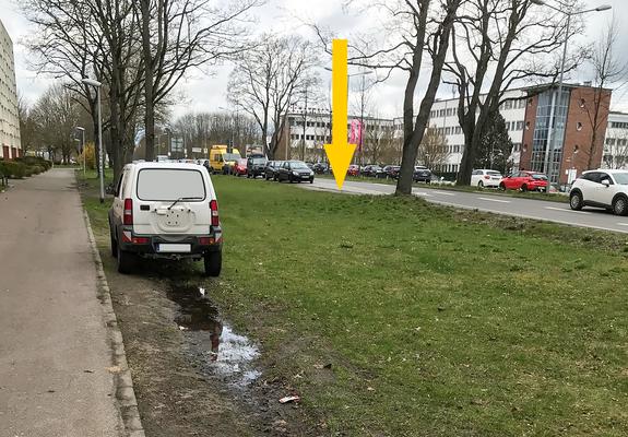 Obwohl ausreichend freie Parkplätze in der Grevesmühlener Straße vorhanden sind (gelber Pfeil), parken häufig Fahrzeuge auf der öffentlichen Grünfläche, Foto: SDS