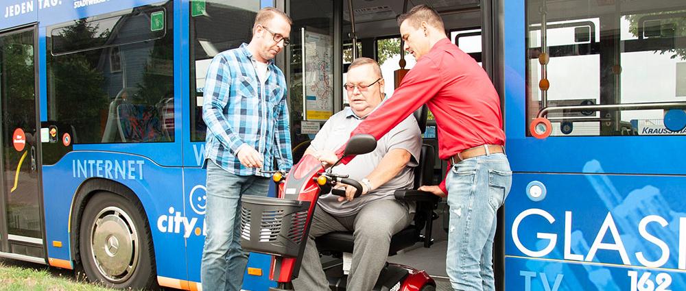 Hartmut Burkhart (m.) bekommt von den NVS-Mitarbeitern gezeigtt, wie er sich mit seinen E-Scooter im Bus verhalten sollte