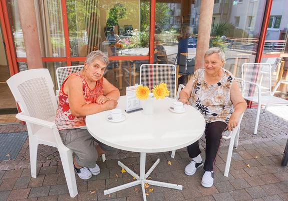 Die Bewohner der Egon-Erwin-Kisch-Straße machen es sich im Außenbereich des Café Kisch unter der Markise gemütlich, Foto: WGS
