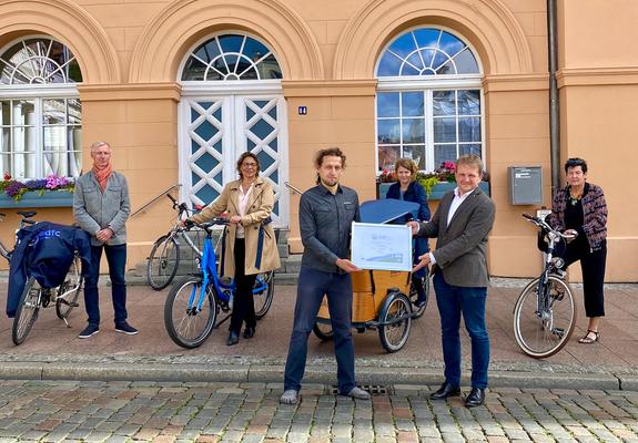 ADFC-Berater Renè Tober (links) überreicht die Auszeichnung „Fahrradfreundlicher Arbeitgeber“ in Silber an Oberbürgermeister Rico Badenschier.