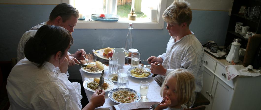 Eine Familie sitzt in der Häuslerei zum Essen zusammen, Foto: Freilichmtmuseum Mueß/Fred-Ingo Pahl