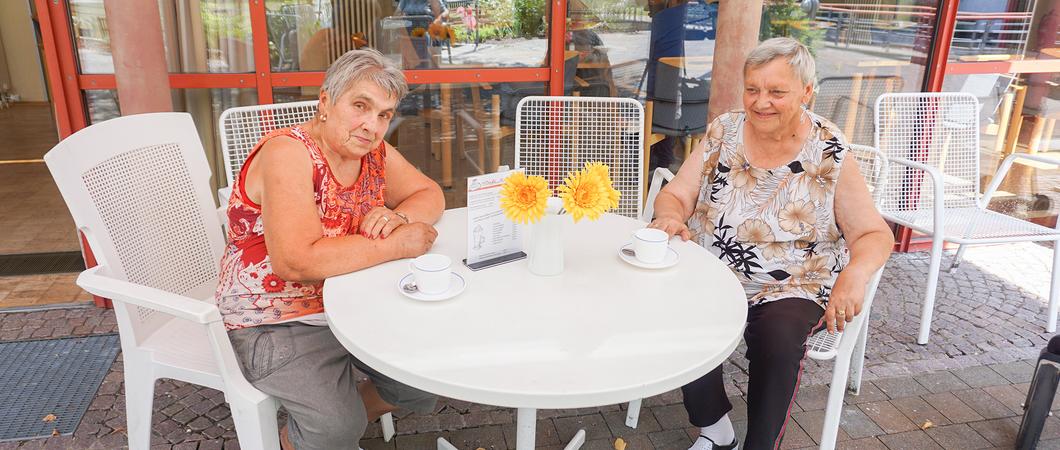 Die Bewohner der Egon-Erwin-Kisch-Straße machen es sich im Außenbereich des Café Kisch unter der Markise gemütlich, Foto: WGS
