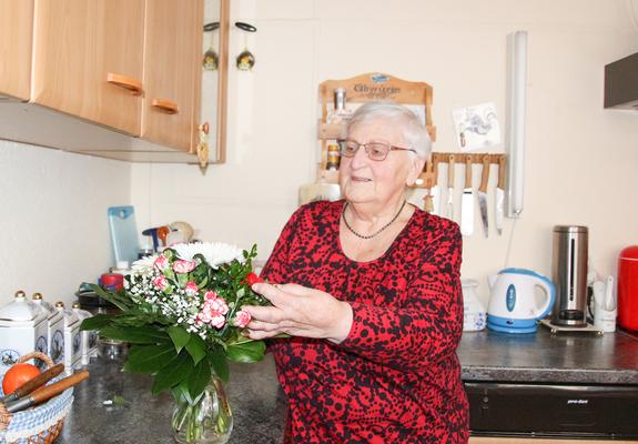 Zum 40. Wohnjubiläum hat die WGS Erika Wendland einige kleine Präsente und einen Blumenstrauß überreicht. Diesen arrangiert sie liebevoll in ihrer Wohnküche