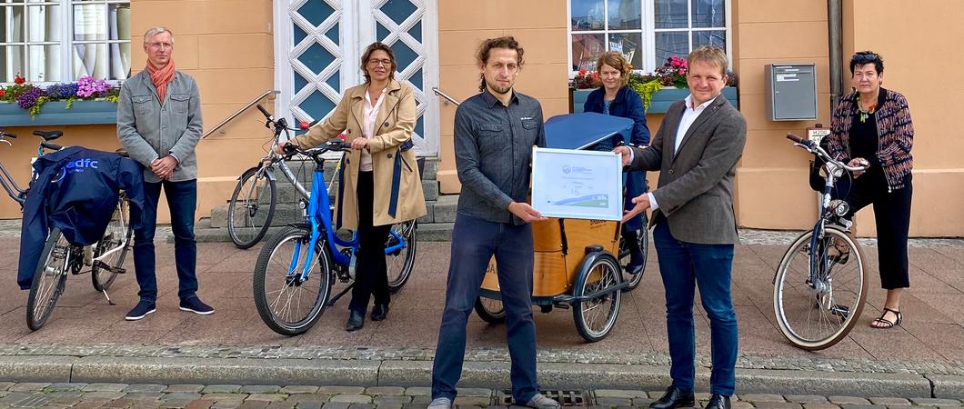 ADFC-Berater Renè Tober (links) überreicht die Auszeichnung „Fahrradfreundlicher Arbeitgeber“ in Silber an Oberbürgermeister Rico Badenschier.