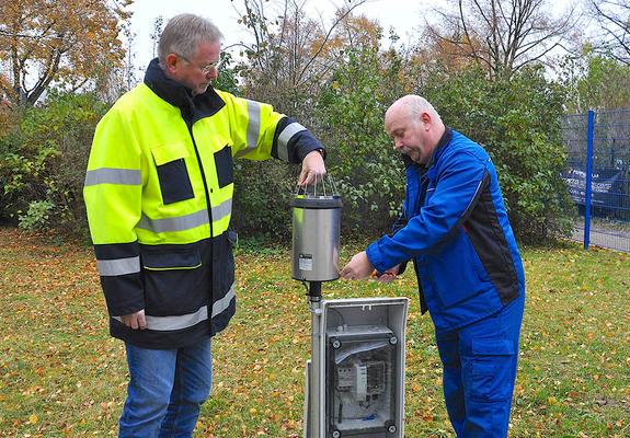 Jörg Hahn und Dirk Haschke (r.) von der WAG prüfen den Regenmesser in der Mecklenburgstraße