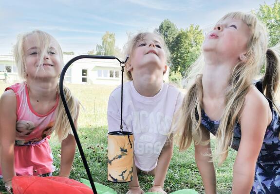 Drinnen flitzen einige Kinder über die Spielflure oder testen ihr Geschick an einer Klangschale mit Wasser. Draußen haben sich Elay, Justus und Egon einen Pferdestall aus Kisten gebaut.