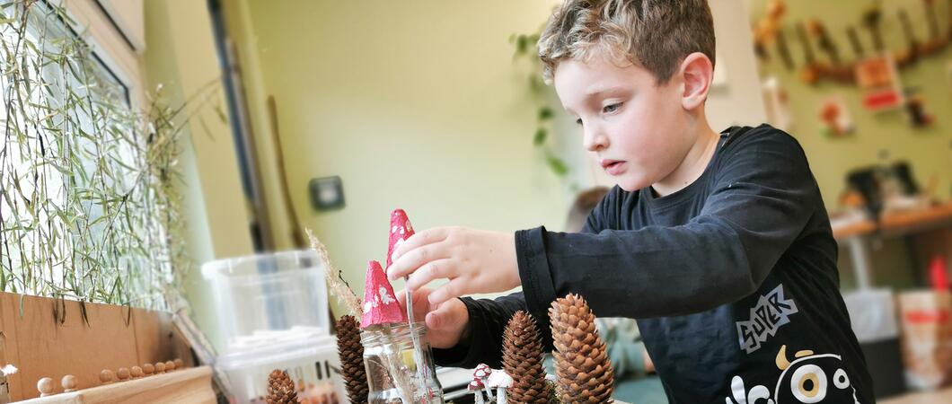 Die Kita „Gänseblümchen“ hat im Juni 2023 ihr neues Gebäude bezogen. Schon im Eingangsbereich zeigen die Fotos der Pädagogischen Fachkräfte auf Baumscheiben: Hier werden viele natürliche Materialien eingesetzt. Ein großes Außengelände macht dies möglich